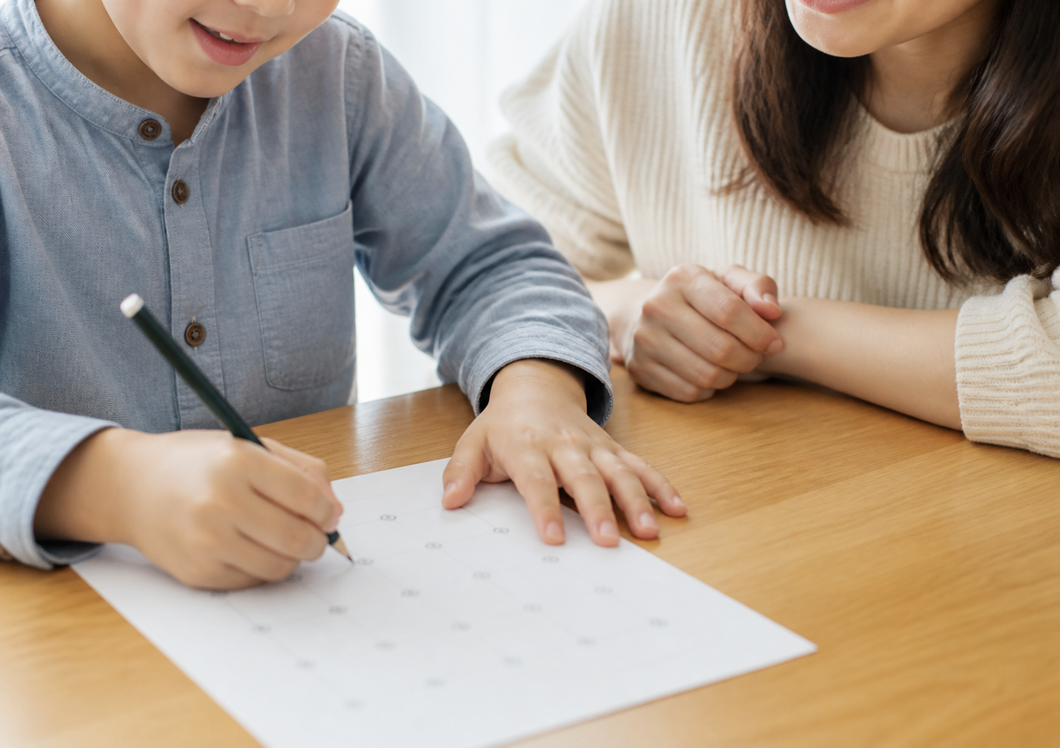 保護者に見守られながら点描写に取り組む幼児の様子